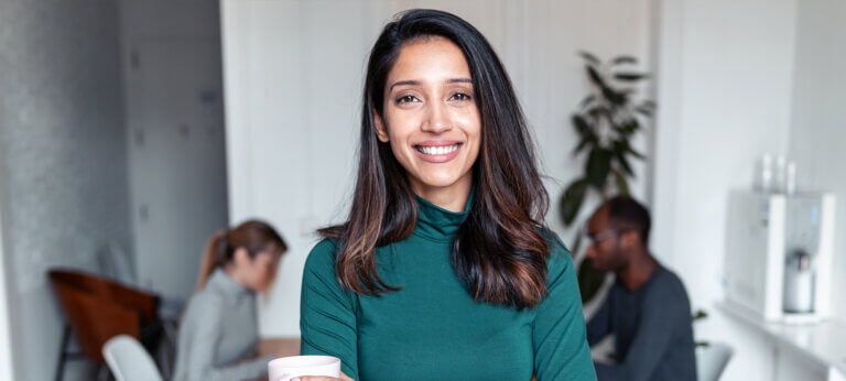 A woman in an office, smiling at the camera