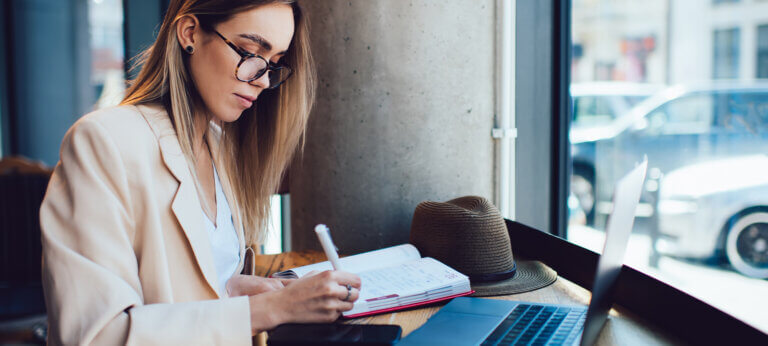 A woman working on a laptop in a cafe