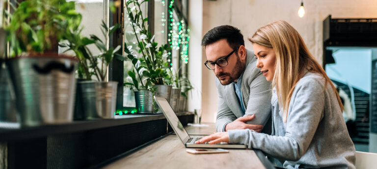 Two people sending an invoice on a laptop