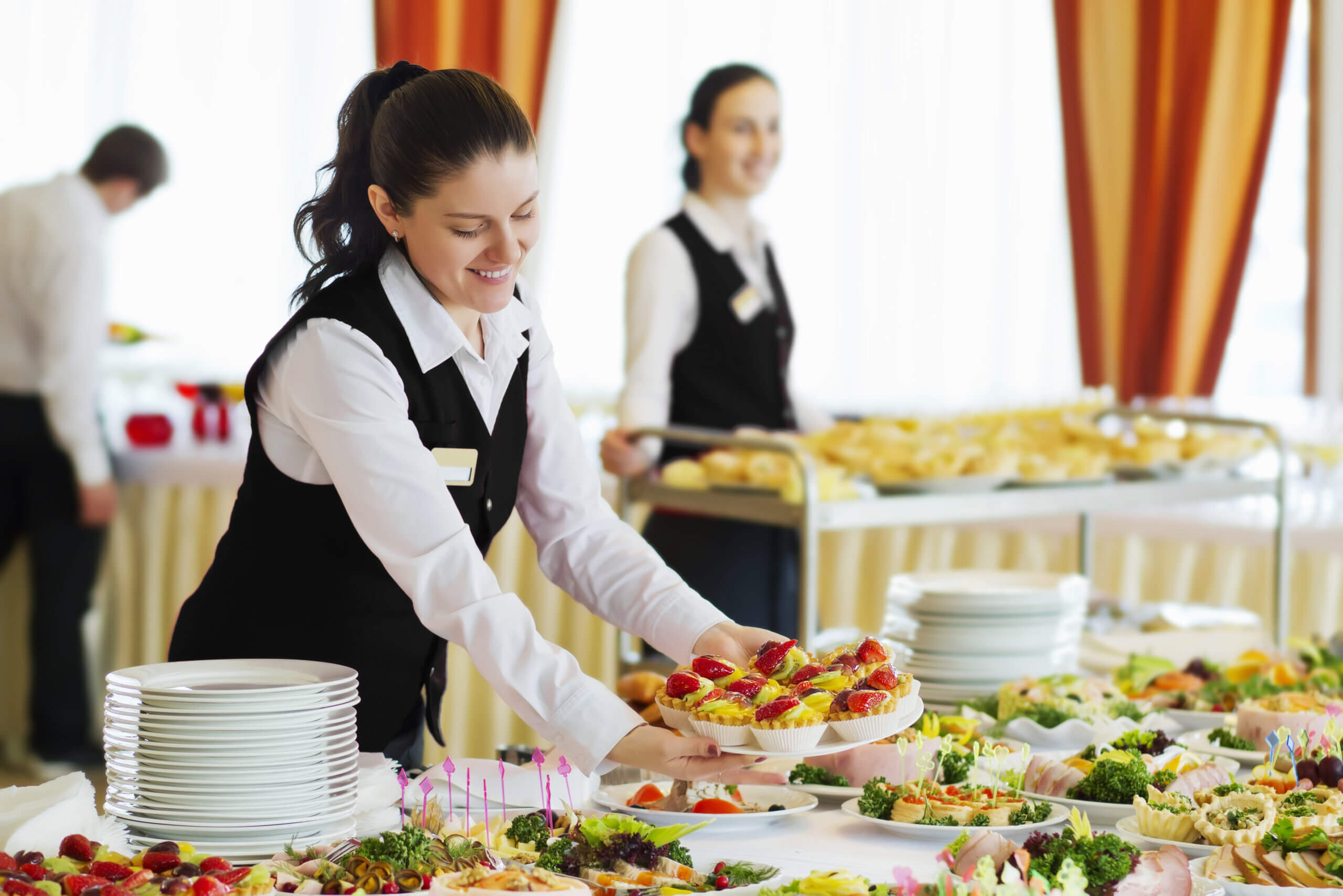 A caterer business woman set the tables in the restaurant for the banquet