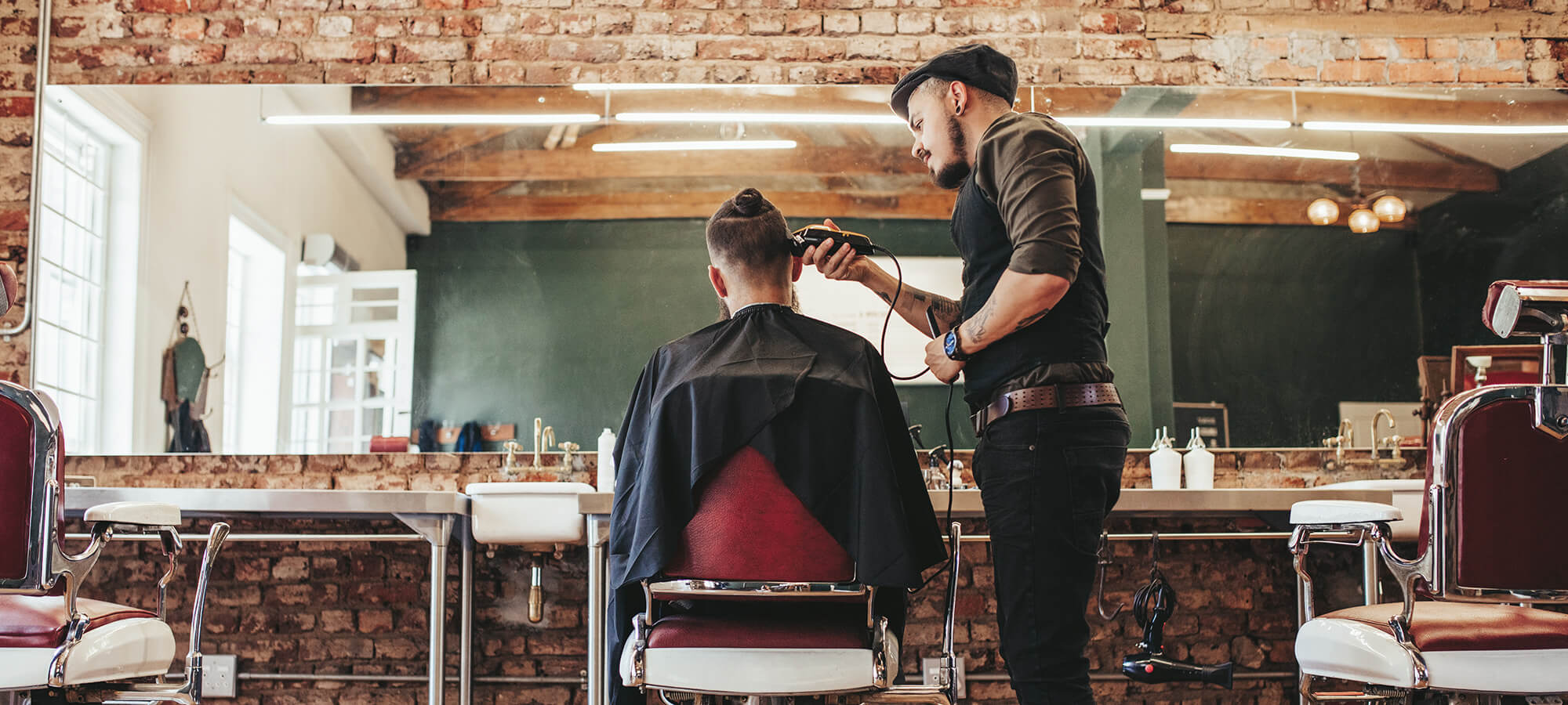 man visiting the barber shop, male barber doing his job