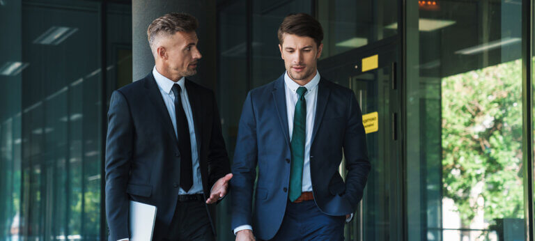 Portrait of two concentrated businessmen partners having conversation outside job center during working meeting