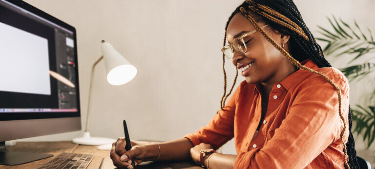 A smiling woman working on her laptop