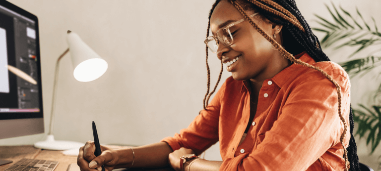 A smiling woman working on her laptop