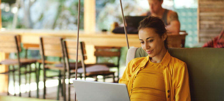 A smiling woman working on her laptop