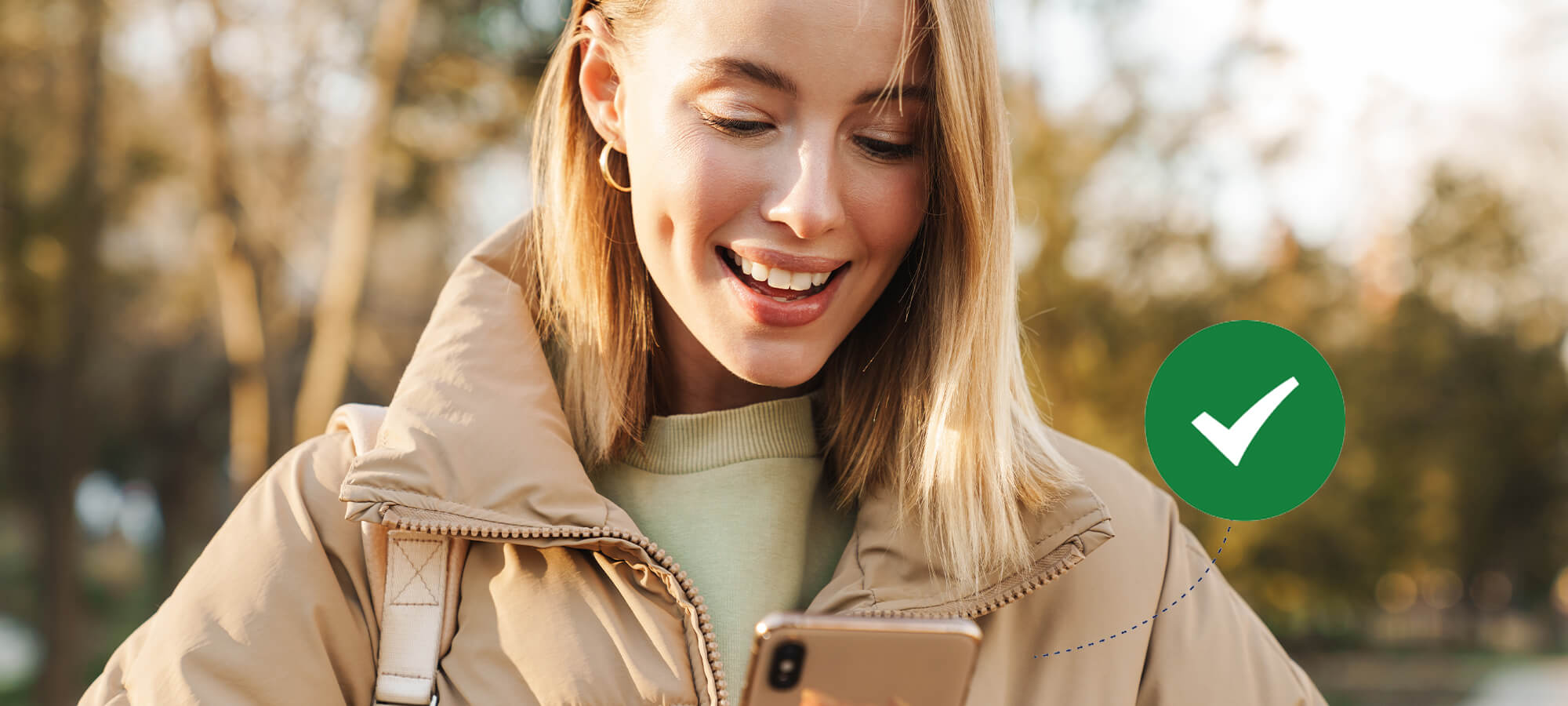 A woman holding her phone and smiling because she got paid fast