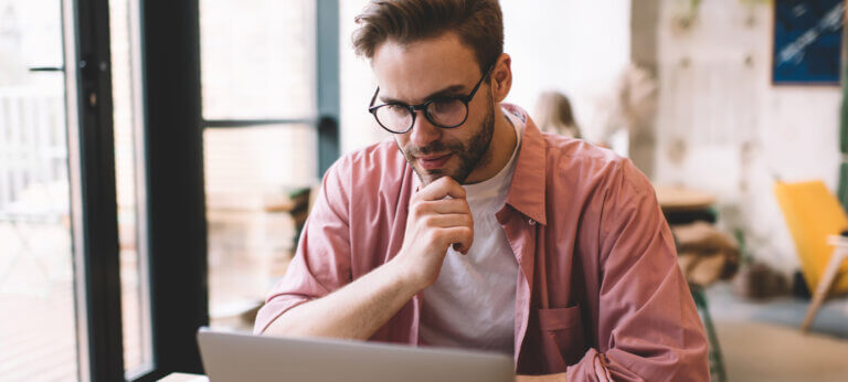 A man trying to write off an invoice on his laptop