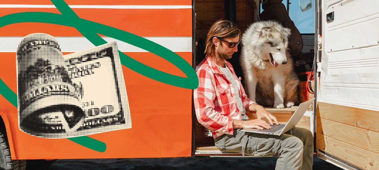 A man in a camper van working on his laptop to set a selling price while a dog looks on