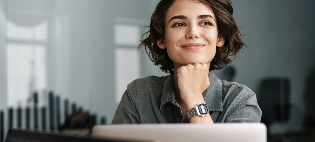 A woman at her laptop, thinking